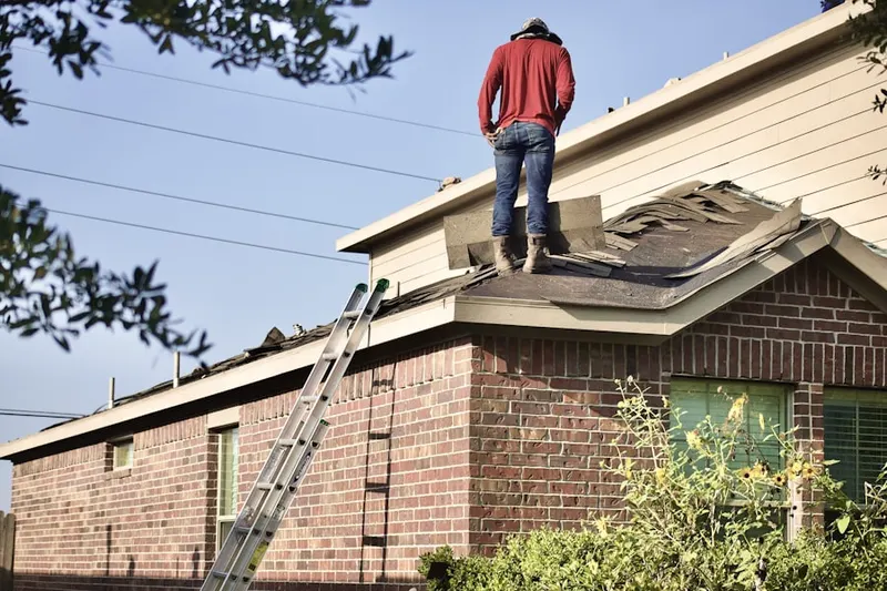 Professional roofer working on a residential roof in Stone